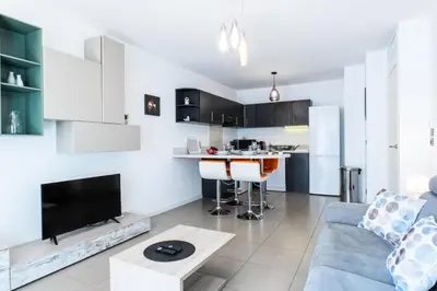 a living room with a couch and a kitchen at Résidence 2p Avec Piscine Au Palm Beach - 2P avec piscine au Palm Beach MAE-2313 in Cannes