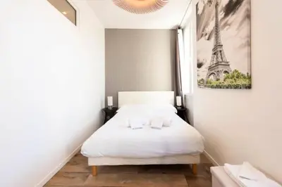 a bedroom with a bed and a picture of the eiffel tower at Résidence Hyper Centre, Croisette, Plages Et Palais à Pied - Hyper centre, Croisette, plages et Palais à pied MAE-2333 in Cannes