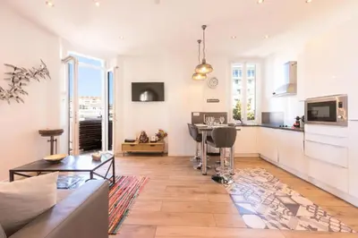 a kitchen and living room with a table and a couch at Résidence Hyper Centre, Croisette, Plages Et Palais à Pied - Hyper centre, Croisette, plages et Palais à pied MAE-2333 in Cannes