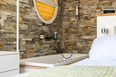 a bathroom with a tub and a bed and a mirror at Résidence Duplex En Toit-terrasse à Deux Pas De La Croisette - Duplex en toit-terrasse à deux pas de la Croisette MAE-2383 in Cannes