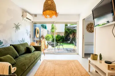 a living room with a green couch and a flat screen tv at Résidence 2p Cozy Avec Jardin En Plein Coeur Du Palm Beach - 2P cozy avec jardin en plein coeur du Palm Beach MAE-2403 in Cannes