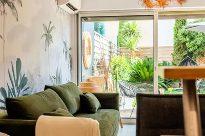a living room with a green couch and a patio at Résidence 2p Cozy Avec Jardin En Plein Coeur Du Palm Beach - 2P cozy avec jardin en plein coeur du Palm Beach MAE-2403 in Cannes