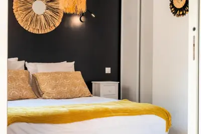 a bedroom with a bed with a yellow blanket on it at Résidence 2p Cozy Avec Jardin En Plein Coeur Du Palm Beach - 2P cozy avec jardin en plein coeur du Palm Beach MAE-2403 in Cannes