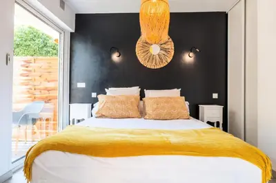 a bedroom with a large bed with a black wall at Résidence 2p Cozy Avec Jardin En Plein Coeur Du Palm Beach - 2P cozy avec jardin en plein coeur du Palm Beach MAE-2403 in Cannes