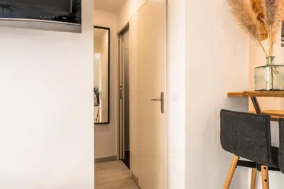a room with a door and a table and a chair at Résidence 2p Cozy Avec Jardin En Plein Coeur Du Palm Beach - 2P cozy avec jardin en plein coeur du Palm Beach MAE-2403 in Cannes