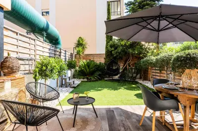 a patio with a table and chairs and an umbrella at Résidence 2p Cozy Avec Jardin En Plein Coeur Du Palm Beach - 2P cozy avec jardin en plein coeur du Palm Beach MAE-2403 in Cannes
