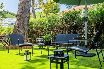 a group of chairs and tables under an umbrella at Résidence Rare ! Rez-de-jardin 10 Minutes à Pied Du Centre - RARE ! Rez-de-jardin 10 minutes à pied du centre MAE-2413 in Cannes