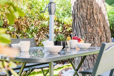 a table with bowls and plants on it in front of a tree at Résidence Rare ! Rez-de-jardin 10 Minutes à Pied Du Centre - RARE ! Rez-de-jardin 10 minutes à pied du centre MAE-2413 in Cannes