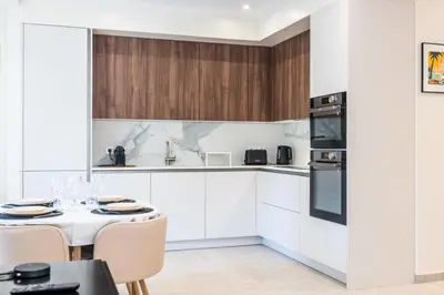 a kitchen with white cabinets and a table and chairs at Résidence Rare ! Rez-de-jardin 10 Minutes à Pied Du Centre - RARE ! Rez-de-jardin 10 minutes à pied du centre MAE-2413 in Cannes
