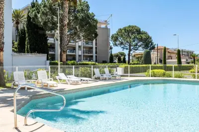 a swimming pool with lounge chairs next to a building at Résidence 3p De Standing, Piscine, Vue Mer, à 2 Pas Des Plages - 3P de standing, piscine, vue mer, à 2 pas des plages MAE-2423 in Cannes