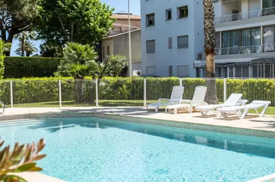 a swimming pool with lounge chairs next to a building at Résidence 3p De Standing, Piscine, Vue Mer, à 2 Pas Des Plages - 3P de standing, piscine, vue mer, à 2 pas des plages MAE-2423 in Cannes