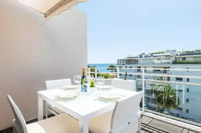 a white dining room with a view of the ocean at Résidence 3p De Standing, Piscine, Vue Mer, à 2 Pas Des Plages - 3P de standing, piscine, vue mer, à 2 pas des plages MAE-2423 in Cannes