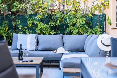 a blue couch sitting on a patio with plants at Résidence Rare ! Studio Avec Terrasse à 5 Min à Pied Du Palais - Rare ! Studio avec terrasse à 5 min à pied du Palais MAE-2433 in Cannes