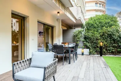a patio with a table and chairs on a lawn at Résidence 3p Centre-ville Avec Jardin, 1min De La Croisette - 3P centre-ville avec jardin, 1min de la Croisette MAE-2443 in Cannes