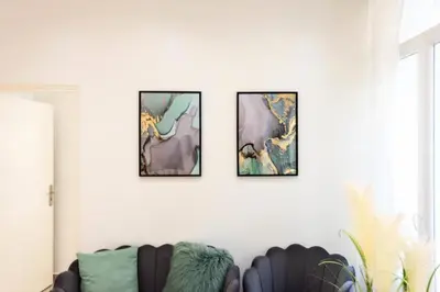 four paintings on a white wall with a couch at Résidence Appartement Moderne En Plein Centre Ville ! - Appartement moderne en plein centre ville ! MAE-2463 in Cannes