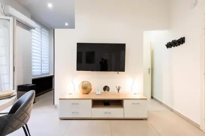 a living room with a tv on a white wall at Résidence Appartement Moderne En Plein Centre Ville ! - Appartement moderne en plein centre ville ! MAE-2463 in Cannes