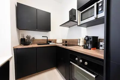 a kitchen with black cabinets and a counter top at Résidence Appartement Moderne En Plein Centre Ville ! - Appartement moderne en plein centre ville ! MAE-2463 in Cannes