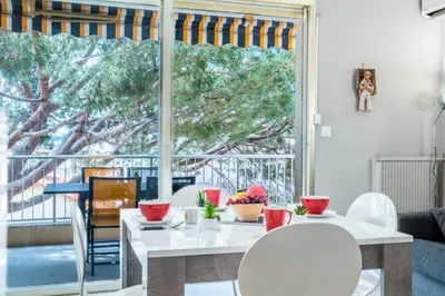 a living room with a table and chairs and a large window at Résidence 2p Avec Terrasse, Vue Mer Et Parking - 2P avec terrasse, vue mer et parking MAE-2483 in Cannes