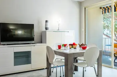 a dining room with a table with chairs and a television at Résidence 2p Avec Terrasse, Vue Mer Et Parking - 2P avec terrasse, vue mer et parking MAE-2483 in Cannes