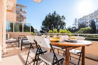 a patio with a wooden table and chairs on a balcony at Résidence 3p Lumineux Avec Terrasse à 15min à Pied Du Palais - 3P lumineux avec terrasse à 15min à pied du Palais MAE-2493 in Cannes