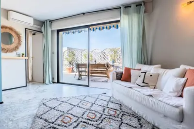 a living room with a white couch and a large window at Résidence 3p Rooftop Palm Beach, Plages à 2min à Pied - 3P Rooftop Palm Beach, plages à 2min à pied MAE-2503 in Cannes