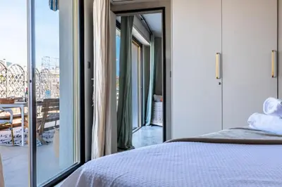 a bedroom with a bed and a view of a balcony at Résidence 3p Rooftop Palm Beach, Plages à 2min à Pied - 3P Rooftop Palm Beach, plages à 2min à pied MAE-2503 in Cannes
