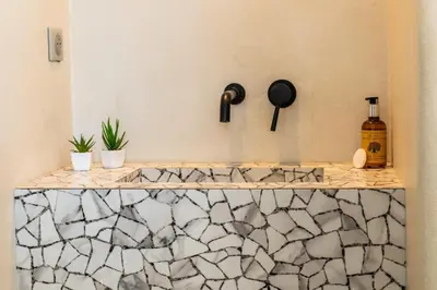 a bathroom with a marble counter with a bottle of alcohol at Résidence 3p Rooftop Palm Beach, Plages à 2min à Pied - 3P Rooftop Palm Beach, plages à 2min à pied MAE-2503 in Cannes