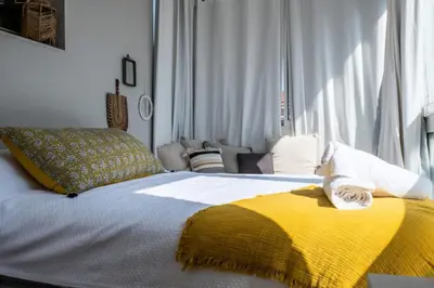a bedroom with a bed with a yellow and white blanket at Résidence 3p Rooftop Palm Beach, Plages à 2min à Pied - 3P Rooftop Palm Beach, plages à 2min à pied MAE-2503 in Cannes
