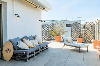 a patio with a blue couch and a chair at Résidence 3p Rooftop Palm Beach, Plages à 2min à Pied - 3P Rooftop Palm Beach, plages à 2min à pied MAE-2503 in Cannes