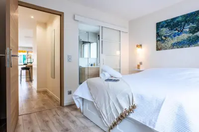 a white bedroom with a large bed and a bathroom at Résidence 2 Pièces Terrasse à 8min à Pied Du Centre Parking - 2 pièces terrasse à 8min à pied du centre parking MAE-2553 in Cannes