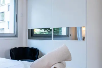 a bedroom with a bed and a chair and a mirror at Résidence 2 Pièces Terrasse à 8min à Pied Du Centre Parking - 2 pièces terrasse à 8min à pied du centre parking MAE-2553 in Cannes