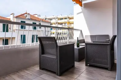 two chairs and a table on a balcony with a building at Résidence 2 Pièces Terrasse à 8min à Pied Du Centre Parking - 2 pièces terrasse à 8min à pied du centre parking MAE-2553 in Cannes