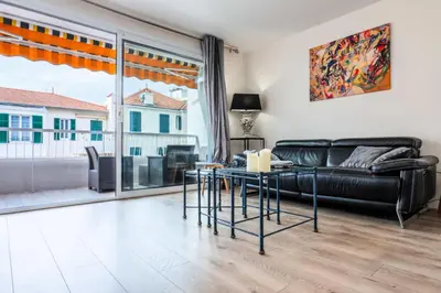 a living room with a black couch and a table at Résidence 2 Pièces Terrasse à 8min à Pied Du Centre Parking - 2 pièces terrasse à 8min à pied du centre parking MAE-2553 in Cannes
