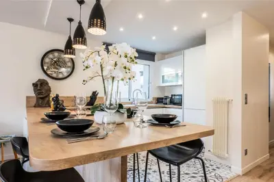 a kitchen with a dining room table with black chairs at Résidence 2 Pièces Terrasse à 8min à Pied Du Centre Parking - 2 pièces terrasse à 8min à pied du centre parking MAE-2553 in Cannes