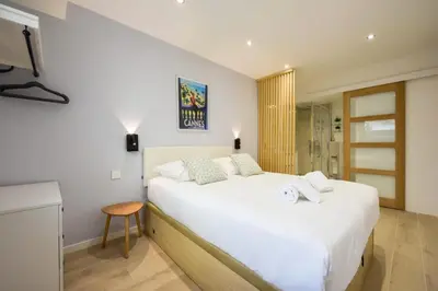 a bedroom with a large white bed and a table at Résidence 3p Haut-de-gamme à 300m Des Plages Croisette - 3p haut-de-gamme à 300m des plages Croisette MAE-2563 in Cannes