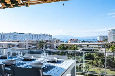 a dining table on a balcony with a view of the city at Résidence 4 Pièces Vue Mer, Terrasse Et Parking - 4 pièces vue mer, terrasse et parking MAE-2573 in Cannes