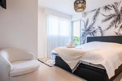 a bedroom with a bed and a chair and a window at Résidence 4 Pièces Vue Mer, Terrasse Et Parking - 4 pièces vue mer, terrasse et parking MAE-2573 in Cannes