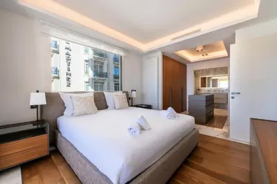 a bedroom with a white bed and a large window at Résidence Rare ! Appartement Grand Standing - Croisette - RARE ! Appartement grand standing - Croisette MAE-2603 in Cannes