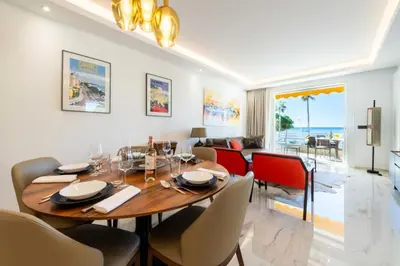 a dining room with a table and chairs and a living room at Résidence Rare ! Appartement Grand Standing - Croisette - RARE ! Appartement grand standing - Croisette MAE-2603 in Cannes