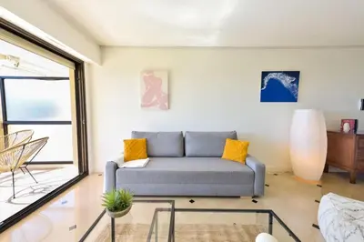 a living room with a couch and a glass table at Résidence 2p Au Calme, Vue Mer, Piscine Et Garage. - 2P au calme, vue mer, piscine et garage. MAE-2633 in Cannes