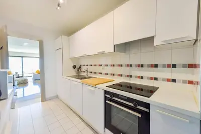 a white kitchen with a sink and a stove at Résidence 2p Au Calme, Vue Mer, Piscine Et Garage. - 2P au calme, vue mer, piscine et garage. MAE-2633 in Cannes
