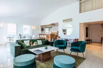 a living room with a green couch and blue chairs at Résidence Rare ! Rooftop 120m² 5min à Pied Du Centre - RARE ! ROOFTOP 120m² 5min à pied du centre MAE-2643 in Cannes