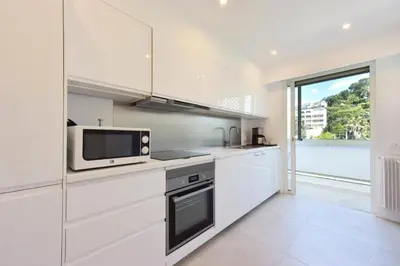 a kitchen with white cabinets and a microwave at Résidence 3p Vue Mer, Plages à Pied & Parking Privé. - 3P vue mer, plages à pied & parking privé. MAE-2663 in Cannes
