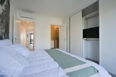 a bedroom with a white bed and a flat screen tv at Résidence 3p Vue Mer, Plages à Pied & Parking Privé. - 3P vue mer, plages à pied & parking privé. MAE-2663 in Cannes