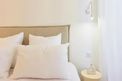 a white bed with white pillows and a table at Résidence 2p De Standing à 100m Du Palais - 2p de standing à 100m du Palais MAE-2683 in Cannes