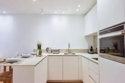 a white kitchen with white cabinets and a sink at Résidence 2p De Standing à 100m Du Palais - 2p de standing à 100m du Palais MAE-2683 in Cannes
