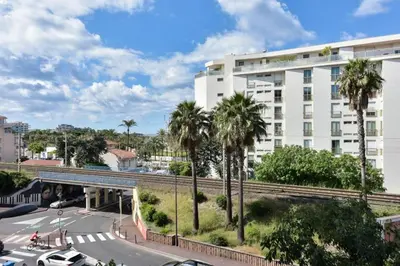 a building with palm trees in front of a street at Résidence Rare 4p Standing Proche Croisette - Rare 4P standing proche Croisette MAE-2713 in Cannes