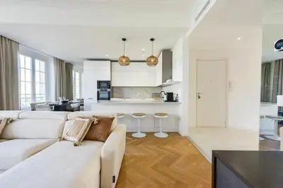 a white living room with a couch and a kitchen at Résidence Rare 4p Standing Proche Croisette - Rare 4P standing proche Croisette MAE-2713 in Cannes