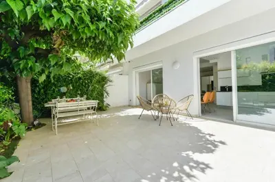 a patio with a table and chairs and a tree at Résidence Rez-de-jardin, Plages à Pied Et Garage - Rez-de-jardin, plages à pied et garage MAE-2723 in Cannes