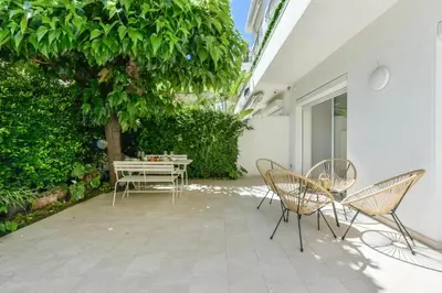 a patio with chairs and a table and a tree at Résidence Rez-de-jardin, Plages à Pied Et Garage - Rez-de-jardin, plages à pied et garage MAE-2723 in Cannes
